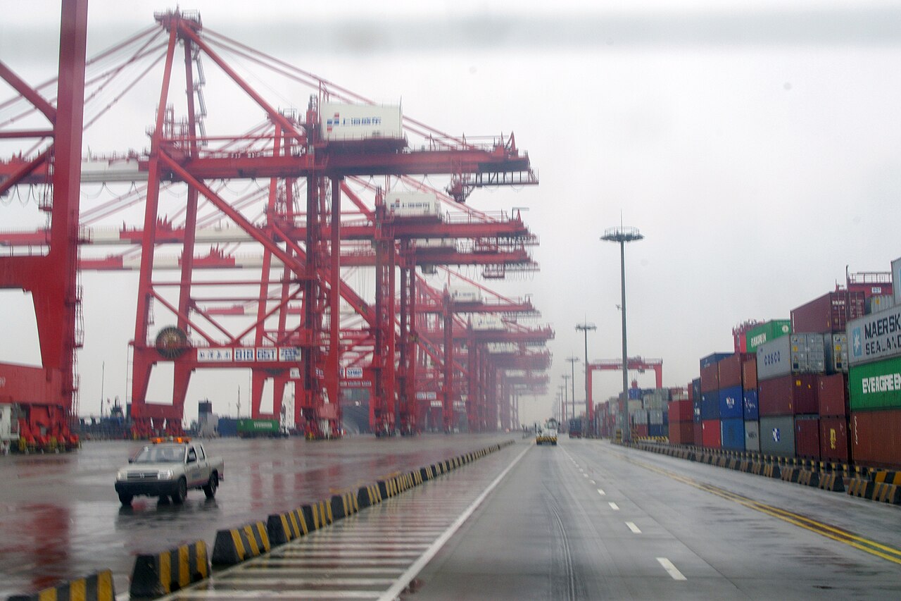 Red ship-to-shore cranes and container stacks at Yangshan port, Shanghai